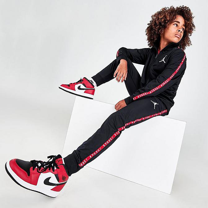 Front view of Boys' Jordan Tape Track Suit in Black/Red Click to zoom