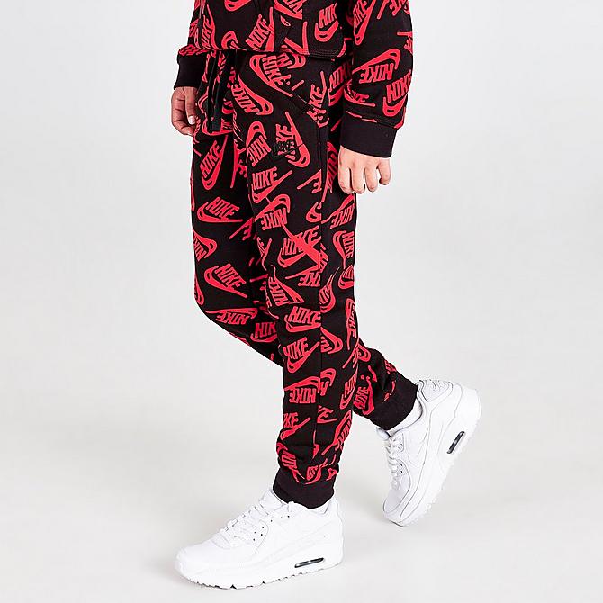 Front Three Quarter view of Kids' Nike Sportswear Allover Logo Jogger Pants in University Red/Black Click to zoom