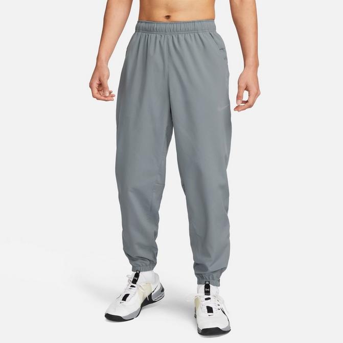 [angle] view of Men's Nike Form Dri-FIT Tapered Versatile Pants in Smoke Grey/Black/Reflective Silver Click to zoom