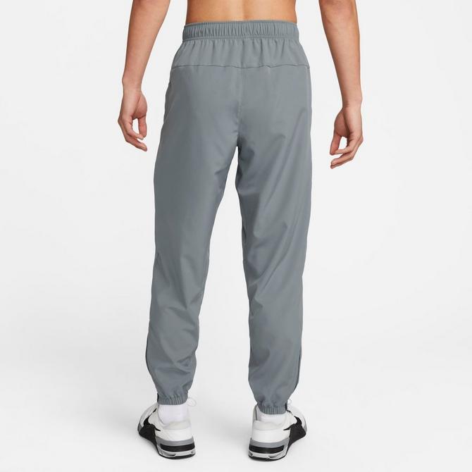 [angle] view of Men's Nike Form Dri-FIT Tapered Versatile Pants in Smoke Grey/Black/Reflective Silver Click to zoom