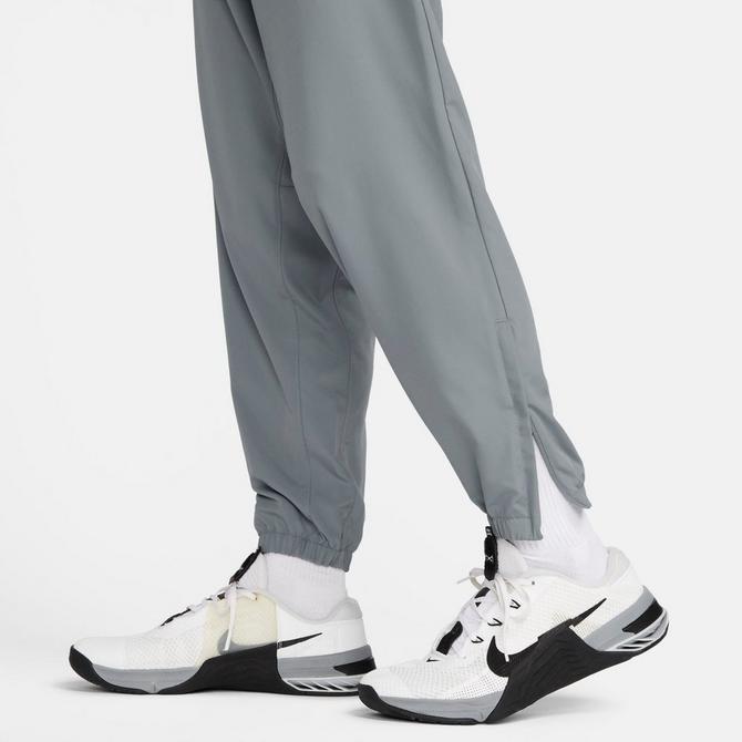 [angle] view of Men's Nike Form Dri-FIT Tapered Versatile Pants in Smoke Grey/Black/Reflective Silver Click to zoom