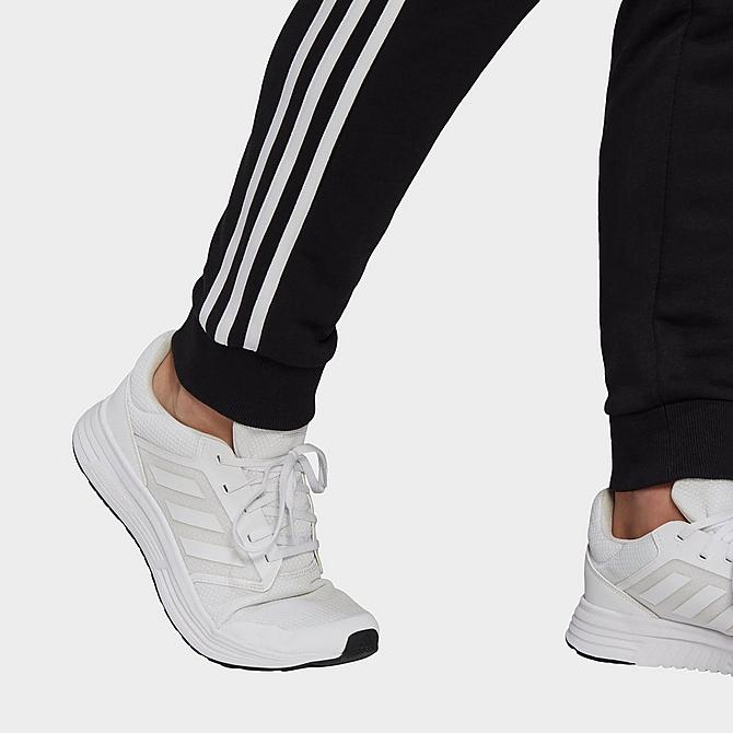 On Model 5 view of Men's adidas Essentials French Terry Tapered Cuff 3-Stripes Pants in Black/White Click to zoom