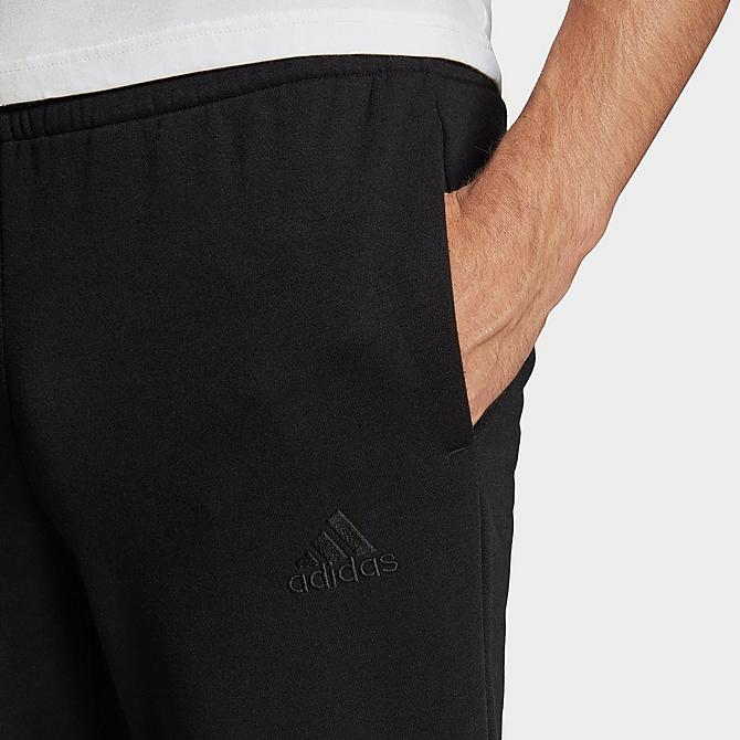 Back Right view of Men's adidas Essentials Tapered Cuff Logo Fleece Pants in Black/White Click to zoom