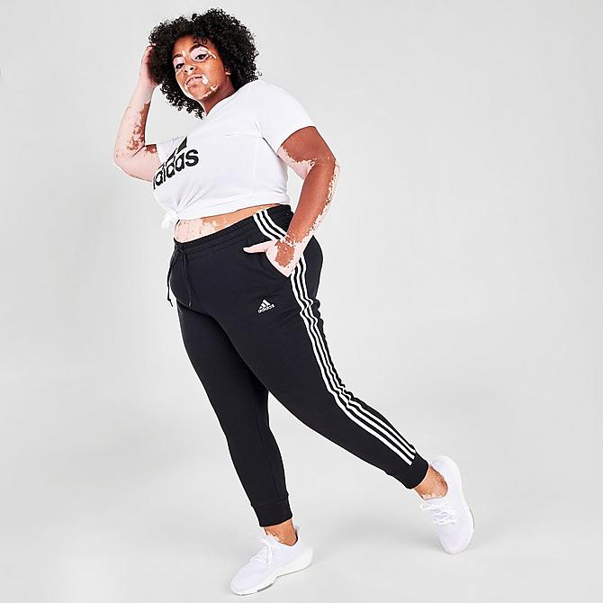 Front Three Quarter view of Women's adidas Essentials 3-Stripes Fleece Jogger Pants (Plus Size) in Black/White Click to zoom
