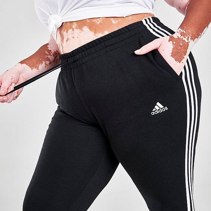 On Model 5 view of Women's adidas Essentials 3-Stripes Fleece Jogger Pants (Plus Size) in Black/White Click to zoom