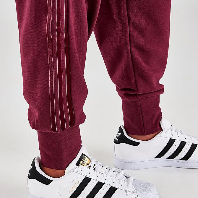 On Model 6 view of Women's adidas Originals Velvet Stripes with Trefoil Rivet Cuffed Pants in Victory Crimson Click to zoom