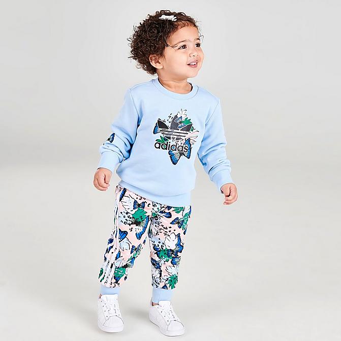 [angle] view of Girls' Infant and Toddler adidas Originals HER Studio London Floral Print Crewneck Sweatshirt and Leggings Set in Clear Sky Click to zoom