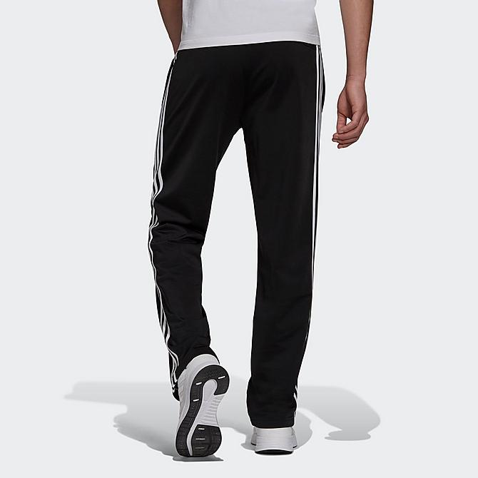 Front Three Quarter view of Men's adidas Warm-Up Tricot Open-Hem 3-Stripe Training Pants in Black/White Click to zoom