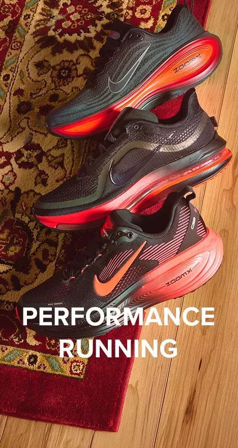 Three men's black Nike ZoomX running shoes with orange soles on a red rug, overlaid with the text "Performance Running."